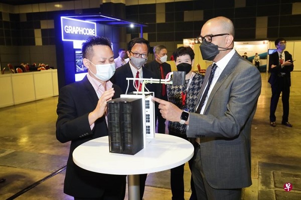 本地企业KoolLogix总裁张焱杰（左）向普杰立医生（右）展示公司的超级电脑冷却系统3D打印模型。张焱杰指出，这套冷却系统也可应用于数据中心。